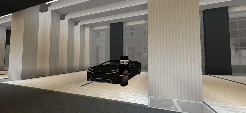 白い建物の前に停めた黒い車とプレイヤー